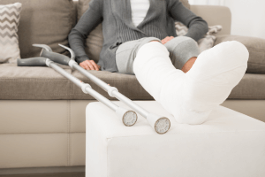 Woman with a cast on her leg sitting on a couch