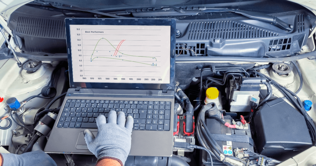 mechanic looking at black box data on laptop