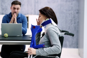 injured woman in wheelchair talking to lawyer