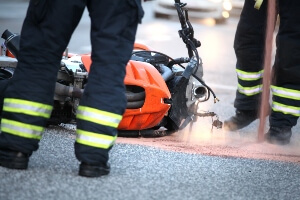 image of a fallen motorcycle and the legs of first responders to a crash.