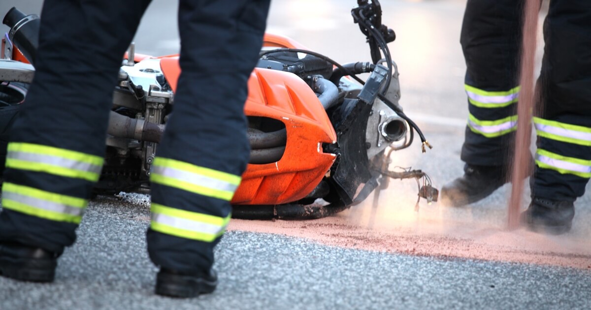 image of a fallen motorcycle and the legs of first responders to a crash.