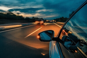 image of a vehicle driving at night on an empty highway