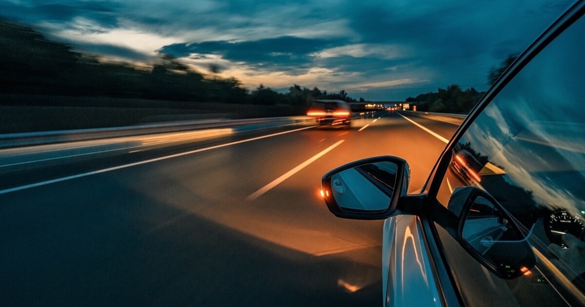 image of a vehicle driving at night on an empty highway